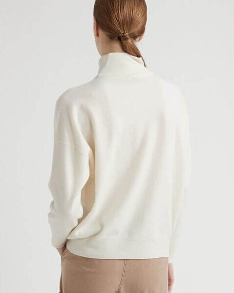 Wełniany golf w kolorze ecru z kaszmirem, zapewniający komfort i ciepło, prezentowany przez modelkę.