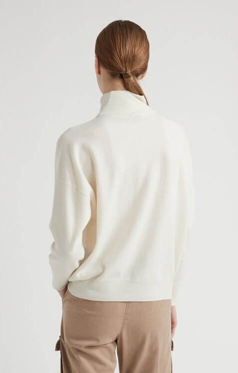Wełniany golf w kolorze ecru z kaszmirem, zapewniający komfort i ciepło, prezentowany przez modelkę.