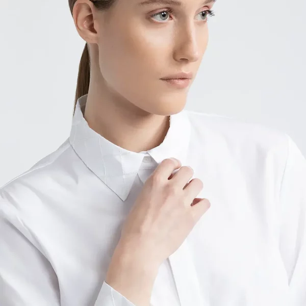 Elegancka biała koszula Peserico z delikatnymi akcentami biżuteryjnymi na kołnierzyku i mankietach, podkreślającymi wyrafinowany charakter stylizacji na formalne okazje.