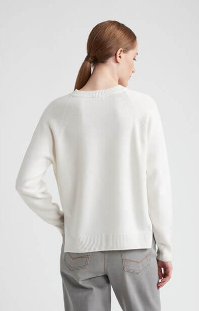 Śmietankowy sweter kaszmirowy z dekoltem w kształcie litery „V” oraz subtelnymi jedwabnymi detalami przy mankietach i wykończeniach.