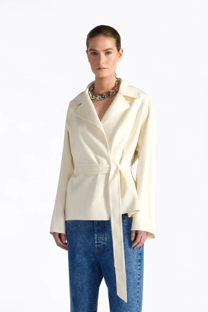 S6FF6SW48A17 0 A Wełniano-jedwabna kurtka z paskiem Elegancka kurtka wykonana z luksusowej mieszanki wełny (90%) i jedwabiu (10%). Model z klasycznymi klapami oraz wiązaniem na pasek, które podkreśla sylwetkę. Długie rękawy i dyskretne, ukryte kieszenie boczne zapewniają funkcjonalność i wygodę. Miękka, szlachetna tkanina nadaje całości wyrafinowany charakter.