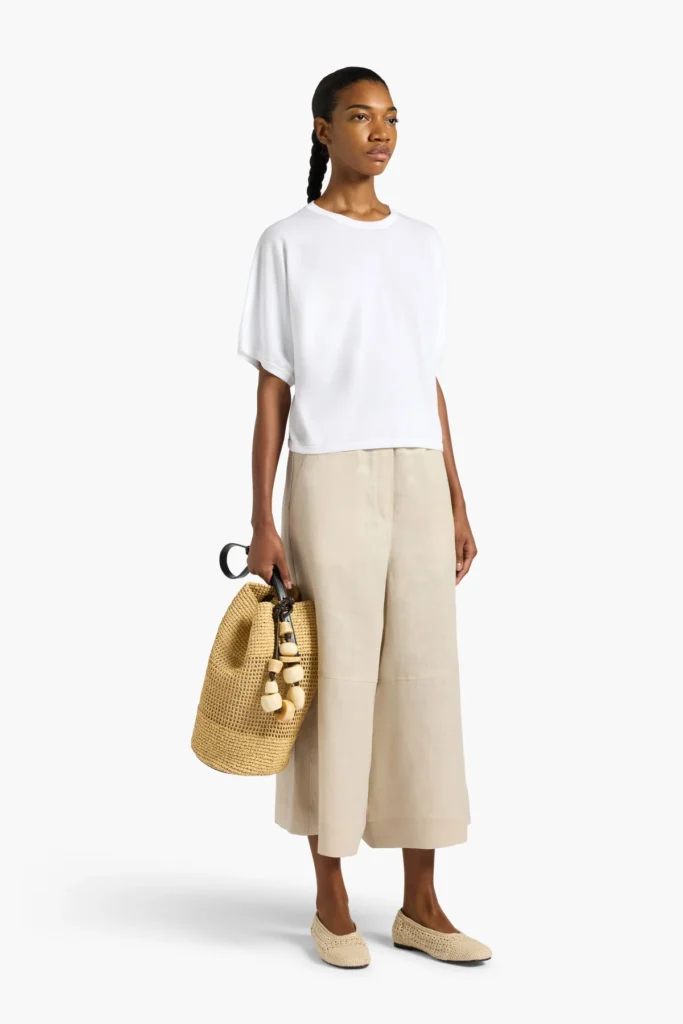 S6LL6SD04A01 0 A Bluzka Liviana Conti wykonana w 100% z wysokiej jakości bawełny to połączenie minimalistycznej elegancji i codziennego komfortu. Model o swobodnym, lekko oversize’owym kroju zapewnia wygodę noszenia i pięknie układa się na sylwetce. Szerokie, krótkie rękawy oraz klasyczny, okrągły dekolt nadają jej nowoczesnego, niewymuszonego charakteru. Naturalna bawełna sprawia, że bluzka jest miękka, przewiewna i przyjemna dla skóry, dzięki czemu idealnie sprawdzi się zarówno w codziennych stylizacjach, jak i w bardziej minimalistycznych, eleganckich zestawach. Neutralny odcień pozwala łatwo łączyć ją z różnymi elementami garderoby- od jeansów po spódnice czy eleganckie spodnie.