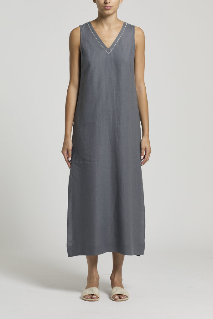 S02168 02647 189 Lniana sukienka Peserico to kwintesencja letniej lekkości, naturalnej elegancji i włoskiego rzemiosła. Wykonana z czystego, wysokiej jakości lnianego płótna, zachwyca przewiewnością, komfortem noszenia oraz subtelnym, swobodnym fasonem. Naturalny len doskonale sprawdza się podczas ciepłych dni, zapewniając świeżość i wyjątkową wygodę przez cały dzień. Model charakteryzuje się miękką, luźno opadającą linią, która delikatnie podkreśla sylwetkę, gwarantując jednocześnie pełną swobodę ruchów. Dekolt w kształcie litery V został ozdobiony charakterystycznym dla marki detalem Punto Luce, który dodaje całości subtelnego blasku i wyrafinowanego charakteru. Tył sukienki przyciąga uwagę delikatnymi marszczeniami oraz regulowanym wiązaniem, pozwalającym na indywidualne dopasowanie fasonu. Niepodszyta konstrukcja sprawia, że model jest niezwykle lekki i przyjemny w noszeniu. Odcień lotniczego błękitu podkreśla świeży, letni charakter sukienki i doskonale komponuje się z naturalnymi dodatkami. W zależności od wybranych akcesoriów może stać się bazą zarówno codziennych, jak i bardziej eleganckich stylizacji. To wyjątkowa propozycja dla kobiet ceniących naturalne tkaniny, ponadczasowy design oraz luksusowe detale, które od lat definiują styl marki Peserico.
