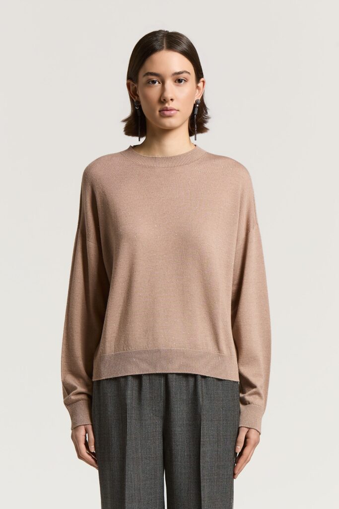 A99269F18 09771 256 Wełniany sweter z lureksem to elegancki model o nowoczesnym, minimalistycznym charakterze. Wykonany z delikatnej wełny z dodatkiem włóczki lureksowej, zachwyca subtelnym połyskiem i szlachetnym wykończeniem. Jednolita struktura dzianiny sprawia, że sweter prezentuje się niezwykle stylowo, a lureksowe akcenty przy okrągłym dekolcie i ściągaczach delikatnie rozświetlają całość. Model wyróżnia się luźnym krojem, który swobodnie układa się na sylwetce i podkreśla współczesny charakter fasonu. Uniwersalna forma sprawia, że sweter można nosić zarówno samodzielnie, jak i pod marynarką, tworząc eleganckie stylizacje warstwowe.