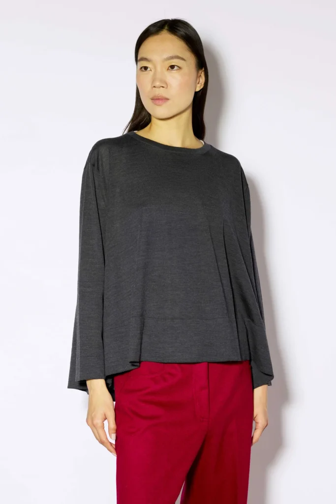 W6FF6WA06Y49 0 B MAGLIA NESTI d190e879 5c86 4bcf af0d 8ca58631e1ad Bluzka z wełny dziewiczej Liviana Conti to propozycja dla kobiet ceniących minimalistyczny fason, wysoką jakość wykonania i ponadczasową elegancję. Model wykonany z miękkiej wełny dziewiczej wyróżnia się luźnym krojem, okrągłym dekoltem oraz długimi, lekko rozszerzanymi rękawami. Prosta forma zapewnia swobodę ruchów, a subtelnie oversize’owy charakter nadaje stylizacji nowoczesny wygląd. Ciemnoszary kolor sprawia, że bluzka z łatwością dopasuje się do wielu zestawów- świetnie prezentuje się zarówno z eleganckimi spodniami, jak i jeansami czy spódnicą. Naturalne właściwości wełny dziewiczej zapewniają komfort noszenia oraz przyjemne otulenie w chłodniejsze dni.